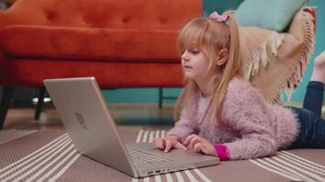 alegre escola criança menina usar computador portátil computador Aprendendo lendo conectados Educação lições sozinho às casa video