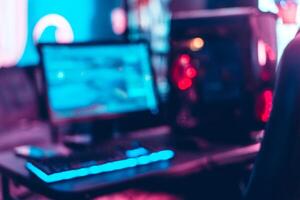 Unfocused and blur background of set up of gamer pc with monitor, keyboard and cpu. photo