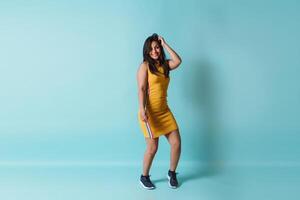 full length of a young happy latinx woman dancing looking at camera with copy space. photo
