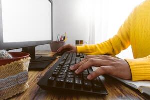 manos de un irreconocible persona mecanografía en un computadora teclado. foto