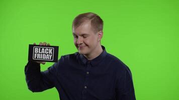 Happy man holding Black Friday inscription, showing thumb up. Guy rejoicing with good sale discounts video