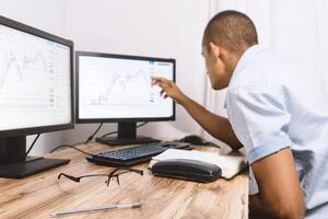a person looking at some graphs on his screen. technology concept and trading classes. photo
