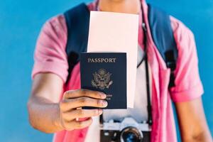 manos de un hombre demostración un pasaporte y un vuelo boleto. foto