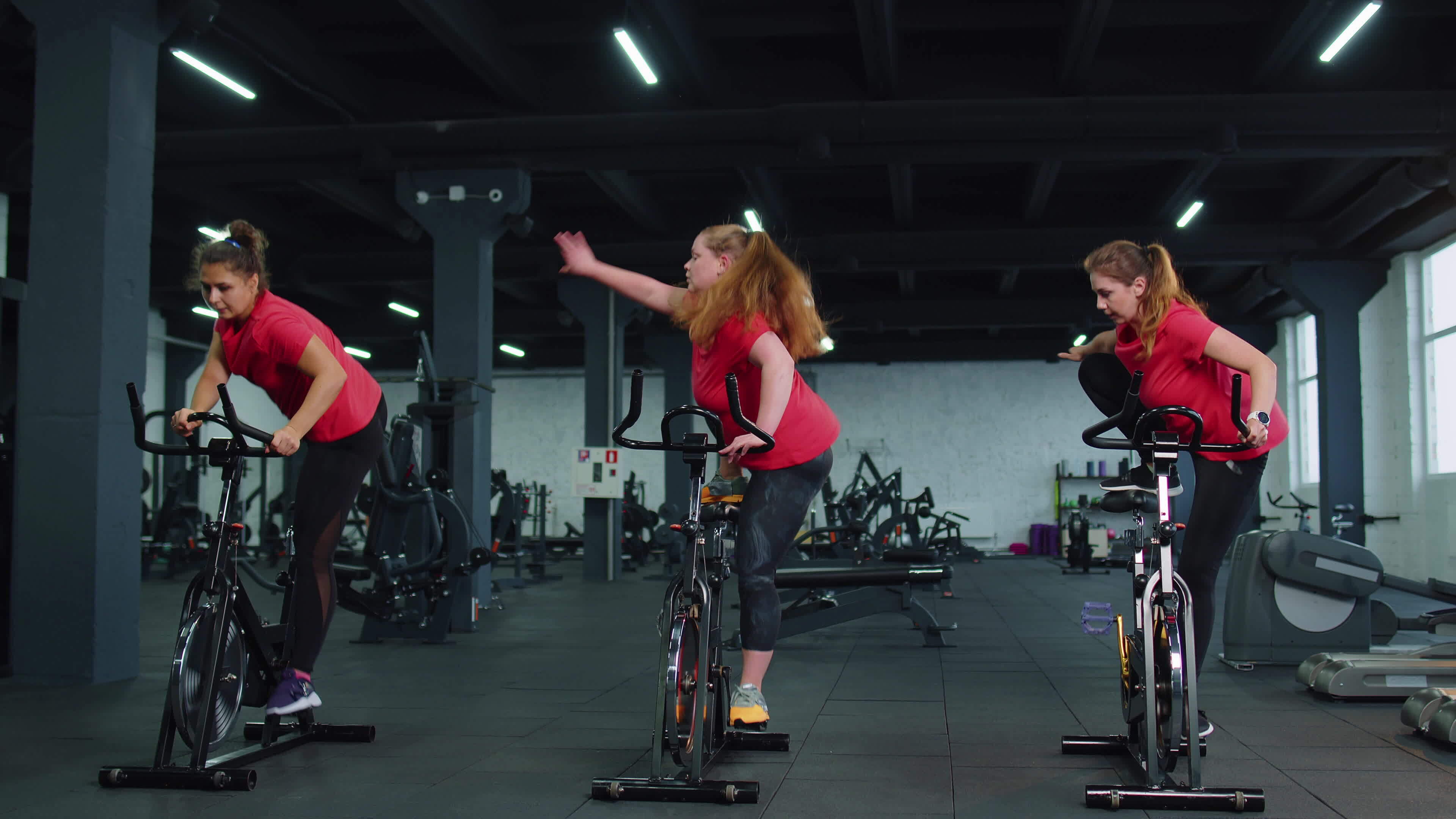 Athletic women group riding on spinning stationary bike training