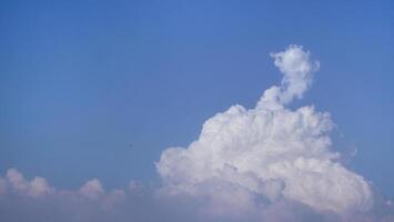 White fluffy clouds open for fantasy idea shape against bright blue sky for background with copy space, graphic resource, cloud motion from the wind photo