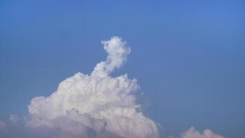 White fluffy clouds open for fantasy idea shape against bright blue sky for background with copy space, graphic resource, cloud motion from the wind photo