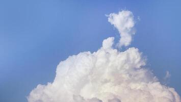White fluffy clouds open for fantasy idea shape against bright blue sky for background with copy space, graphic resource, cloud motion from the wind photo