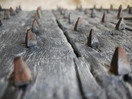 Side view of an old ancient medieval wooden door, close up selective focus at metal rusty iron spiked, concept image for advertising with copy space photo