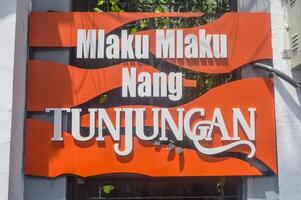 the sign says Mlaku Mlaku Nang Tunjungan, Indonesia, 2 March 2024. photo