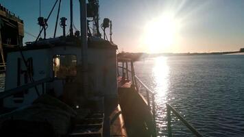 een visie van een aak schip vervoeren goederen. klem. schip Aan kabbelend rivier- met schijnend zon Aan de achtergrond. video