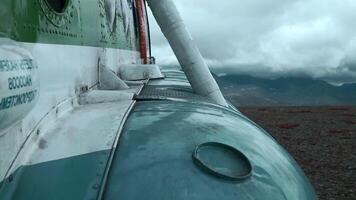 Close up of old rusty airplane on a hill top. Clip. Aircraft exterior details with heavy clouds and mountains on the background. video