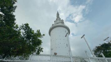 baixo ângulo Visão do uma branco lindo torre em azul nublado céu fundo. Ação. conceito do cultura e arquitetura. video