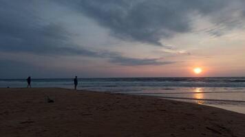 dramático mar amanecer en nublado cielo. acción. ondulado arena mar zapato y un Pareja reunión nuevo día. video