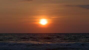 lindo rolando ondas em fundo do configuração Sol. Ação. lindo espuma ondas mover em fundo do brilhante Sol às pôr do sol. laranja Sol sobre mar horizonte com ondas video