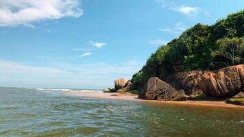 Paradise coastline with rocks and soft sandy beach, lush green forests. Action. Uninhabited island with blue cloudy sky above. video