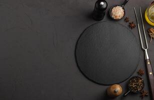 Banner Black stone plate with spices and herbs. Top view. Concept cooking. Free space for your text. photo