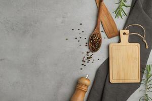 Black pepper and black pepper and spice mill on an old gray concrete background. Food cooking kitchen utensil background and mock up. Top view photo