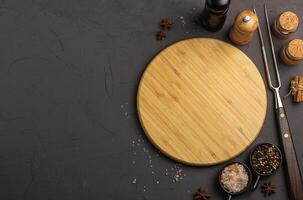 Wooden cooking board with vegetables and spices on a gray concrete background, top view photo