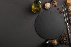 Banner Black stone plate with spices and herbs. Top view. Concept cooking. Free space for your text. photo