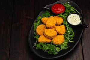 Chicken nuggets with arugula and sauces with copy space photo