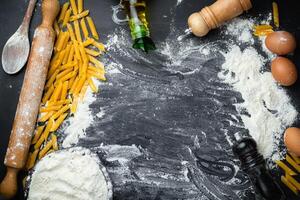 Raw homemade pasta and ingredients for pasta on wooden background. Top view photo