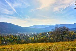 Aerial view of an autumn small village in a valley and mountains in a blue haze photo