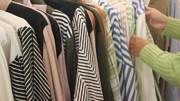 Close up of a woman choosing clothes on a hanger in a mall ahead of Eid al Fitr video