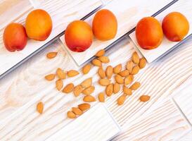 Fresh ripe apricot kernels fruits on wooden photo