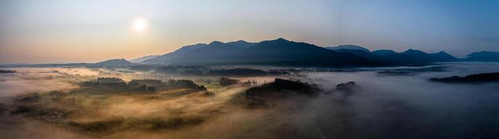 Sunset Panorama with drone at the Bavarian Alps. Mist and fog at the ground photo