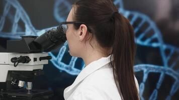 Medical Research Scientist Looks at Biological Samples Under Digital Microscope in Applied Science Laboratory. Beautiful Caucasian Lab Engineer in White Coat Working on Vaccine and Medicine video