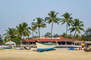 old fishing boats in sand on ocean in India on blue sky background photo