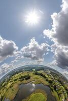 Aerial view from high altitude tiny planet in sky with clouds overlooking old town, urban development, buildings and crossroads. Transformation of spherical 360 panorama in abstract aerial view. photo