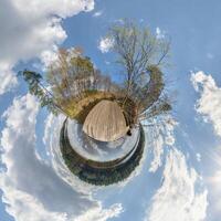 tiny planet transformation of spherical panorama 360 degrees. Spherical abstract aerial view with trees in forest with clumsy branches in blue sky. Curvature of space. photo