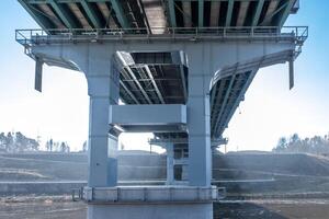 acero marco y hormigón construcción enorme coche puente a través de el amplio río. foto