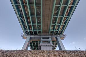 acero marco y hormigón construcción enorme coche puente a través de el amplio río. foto