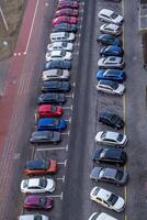 large parking lot for cars in front of a multi-storey residential building view from above photo