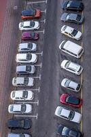 large parking lot for cars in front of a multi-storey residential building view from above photo