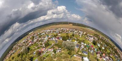 Aerial view from high altitude tiny planet in sky with clouds overlooking old town, urban development, buildings and crossroads. Transformation of spherical 360 panorama in abstract aerial view. photo