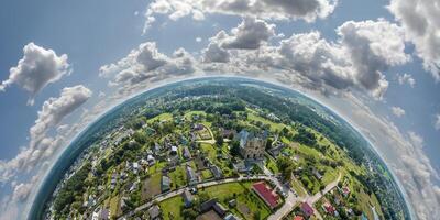 Aerial view from high altitude tiny planet in sky with clouds overlooking old town, urban development, buildings and crossroads. Transformation of spherical 360 panorama in abstract aerial view. photo