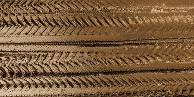 view from above on texture of wet muddy road from above on surface of wet gravel road with tractor tire tracks in countryside photo