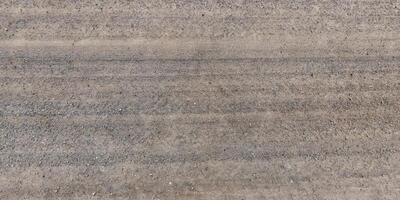 view from above on texture of gravel road with car tire tracks photo