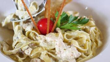 plate of cream and herb pasta on table video