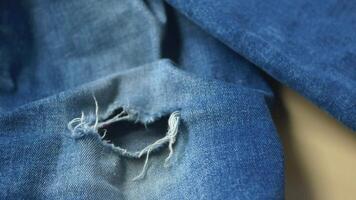 blue jean texture with a hole and ripped threads showing video