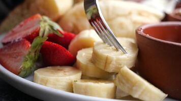 close up of slice of banana and strawberry on a plate video