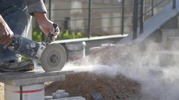 A man is using a grinder to cut a piece of concrete video