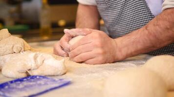 hands form pieces of dough for baking bread and rolls. video