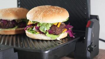 Sandwich with meatballs, lettuce, and red cabbage grilling at home video