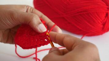 Hand close up crocheting with a hook, wool yarn, creative craft video