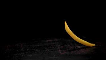 súper lento movimiento de el francés papas fritas caídas en el mesa. en un negro antecedentes. filmado en un alta velocidad cámara a 1000 fps. video