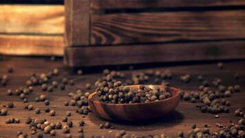 Super slow motion plate with peas of black pepper falls on the table.Filmed on a high-speed camera at 1000 fps. On a wooden background. video